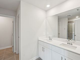 The primary bathroom boasts a dual-sink vanity and walk-in shower.
