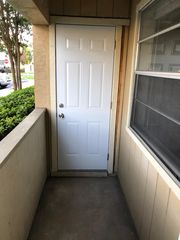 Outdoor covered deck just off living room with storage closet.