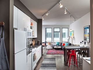 Classic Package I kitchen with white appliances, dark laminate countertops, white cabinetry, tile backsplash, and hard surface flooring
